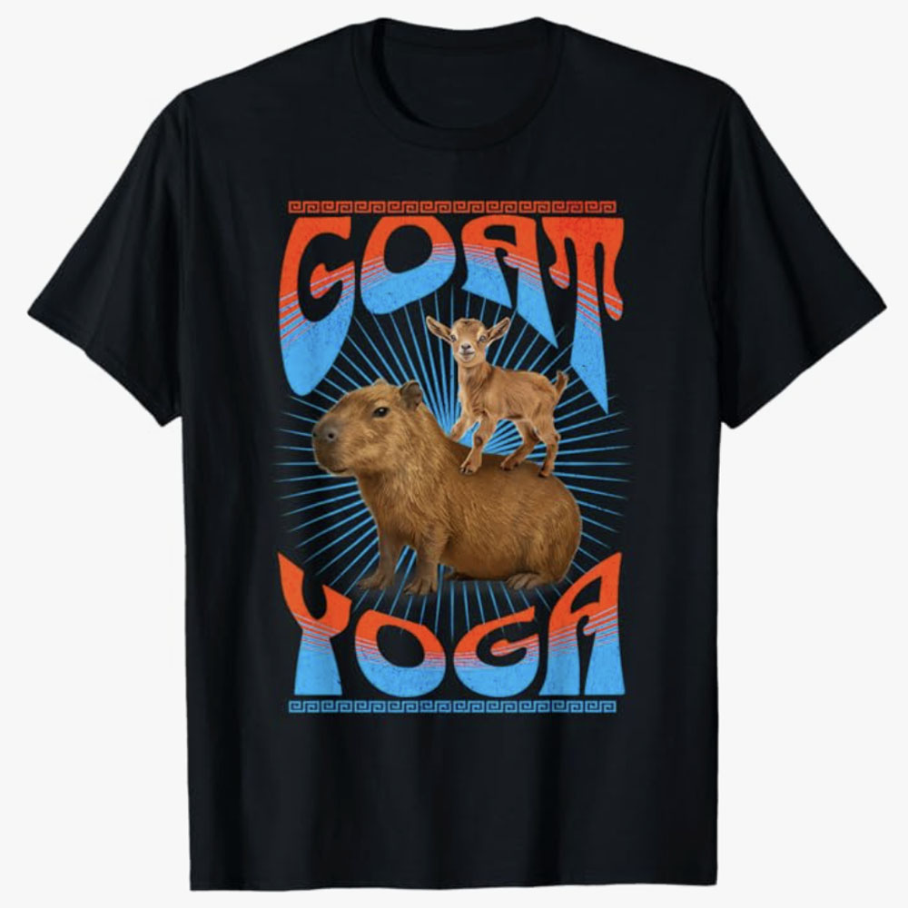 Black T-shirt featuring a playful design of a baby goat standing on a capybara with the words Goat Yoga in bold retro lettering, celebrating humor, relaxation, and animal-themed fun.
