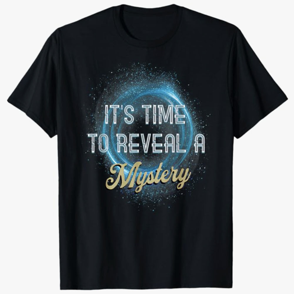 A black T-shirt features glowing blue particles forming a swirling ring behind the words It’s Time to Reveal a Mystery. The design evokes anticipation and excitement, suggesting something magical or surprising is about to be unveiled.