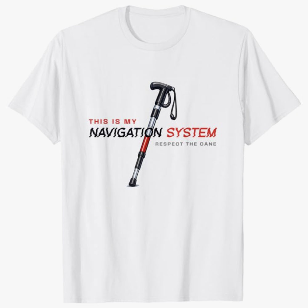 A white T-shirt shows a mobility cane alongside the text This Is My Navigation System with the phrase Respect the Cane underneath. The design promotes disability awareness, respect, and independence for cane users.