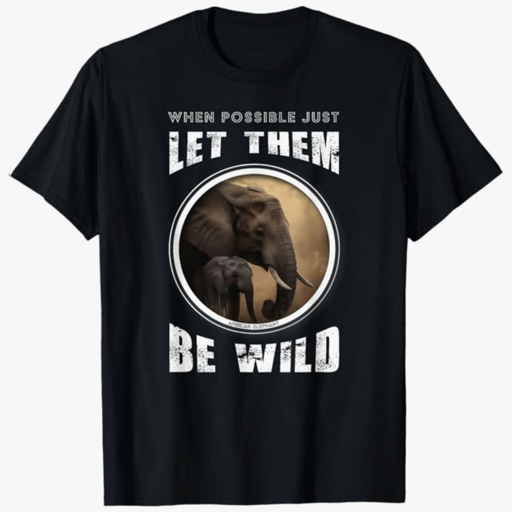 A black T-shirt shows an African elephant and calf inside a circular frame with the words “When possible just let them be wild.” The design emphasizes wildlife protection, family bonds, and respect for animals in their natural habitats.
