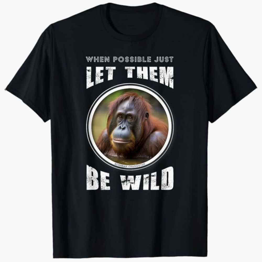 A black T-shirt features a portrait of a Bornean orangutan inside a circular frame with the words “When possible just let them be wild.” The design promotes wildlife conservation and respect for animals living freely in their natural habitats.