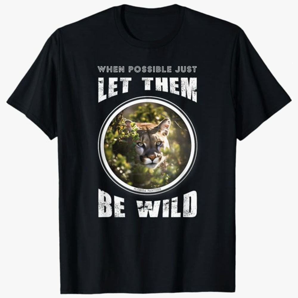 A black T-shirt shows a Florida panther framed in a circle with the words “When possible just let them be wild.” The design highlights wildlife conservation and respect for animals living freely in their natural habitats.