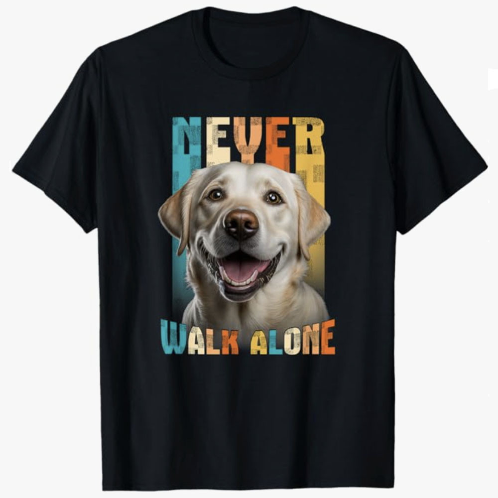 A black T-shirt features a smiling dog portrait with the words “Never Walk Alone,” symbolizing loyalty, companionship, and emotional support. The design conveys comfort, encouragement, and the bond between people and their dogs.