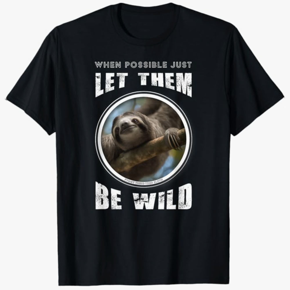 A black T-shirt features a smiling sloth in a circular frame with the words “When possible just let them be wild.” The design promotes wildlife respect, conservation, and letting animals live naturally.