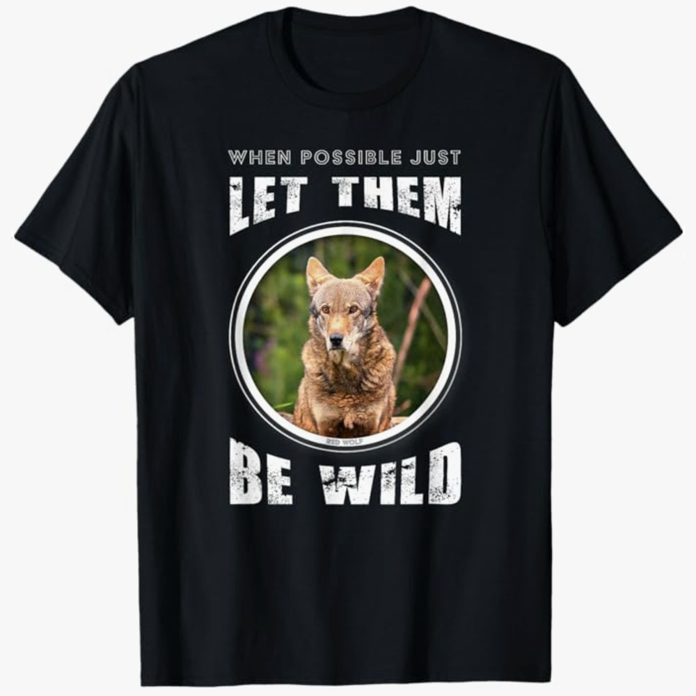 A black T-shirt shows a red wolf with the words “When possible just let them be wild.” The design promotes respect for wildlife and preserving animals in their natural habitats.